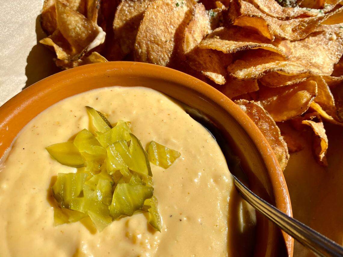 Best Maid Sour Pickle Beer queso with chopped dills and house kettle chips at the Bearded Lady.