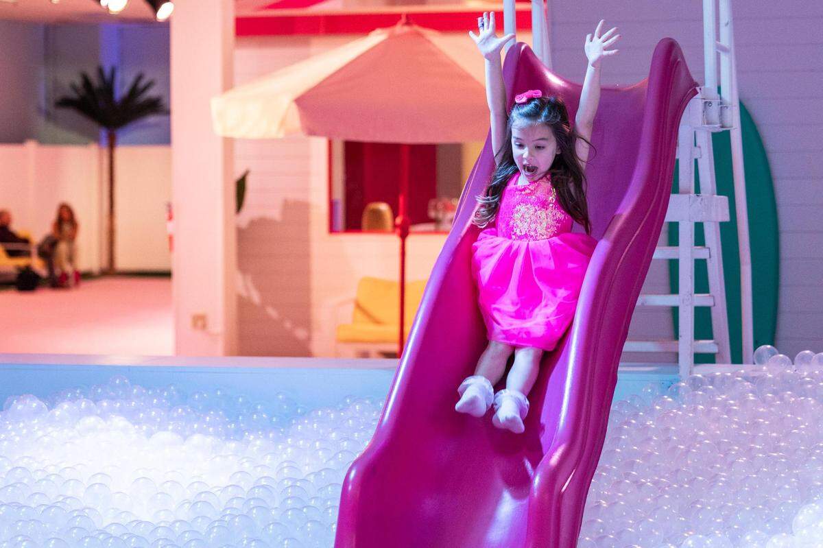 Harper Winters, 5, slides into the ball pit at the ‘World of Barbie’ immersive experience at the Stonebriar Centre in Frisco on Thursday, Nov. 16, 2023.