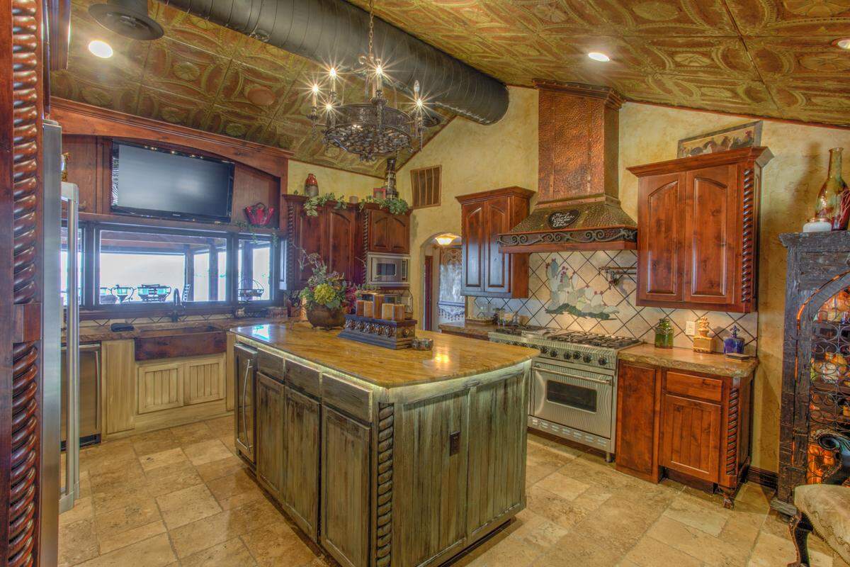 A chef’s kitchen in the 8935 Dickson Rd. house is adorned by iron ceiling tiles that are from the original Mott’s store in Fort Worth.
