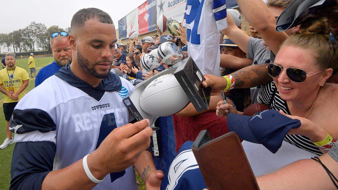 Dallas Cowboys quarterback Dak Prescott (4) signs autographs after the first practice at training camp in Oxnard, CA, Thursday, July 26, 2018.  