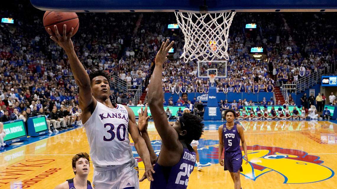 Kansas guard Ochai Agbaji (30) gets past TCU center Souleymane Doumbia (25) to put up a shot during the first half Thursday night in Lawrence. The Jayhawks held off the Frogs 72-68.