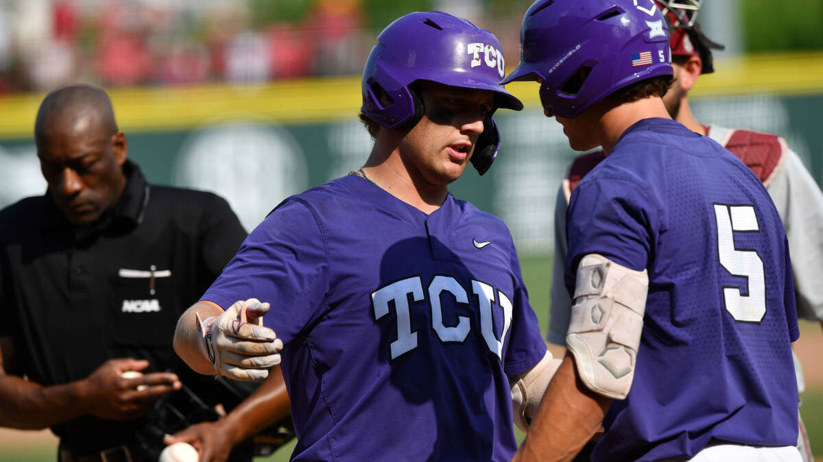 TCU designated hitter Kurtis Byrne, center, celebrates with teammate Anthony Silva (5) after hitting a solo home run against Arkansas during the eighth inning of an NCAA college baseball tournament regional championship game in Fayetteville, Ark. Monday, June 5, 2023. (Andy Shupe/The Northwest Arkansas Democrat-Gazette via AP)