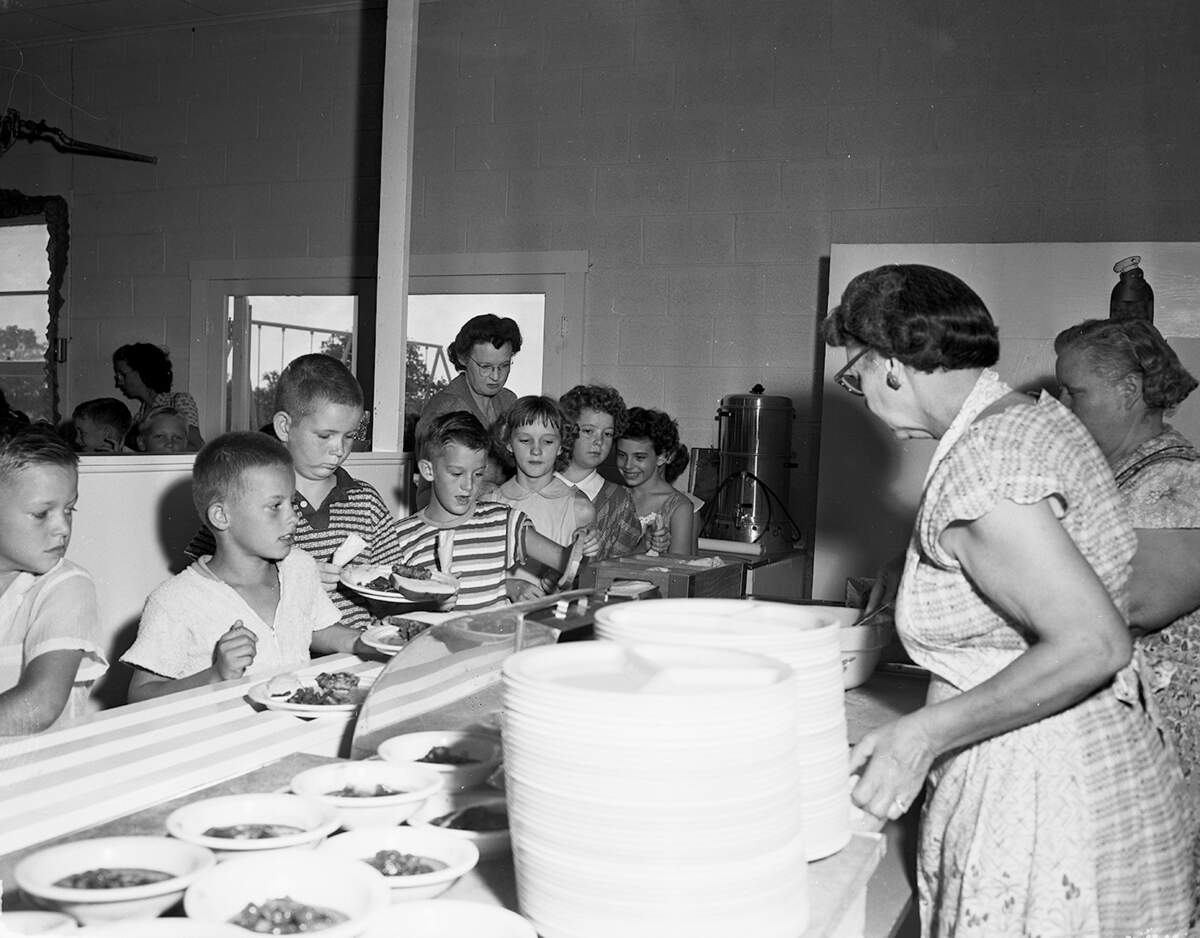 Sept. 7, 1954: Children at the Pleasant Run School had a completed cafeteria in which to eat their lunch on opening day. The cafeteria, opened last year, was completed this year. Serving the children in line is Mrs. Roy Thomas.