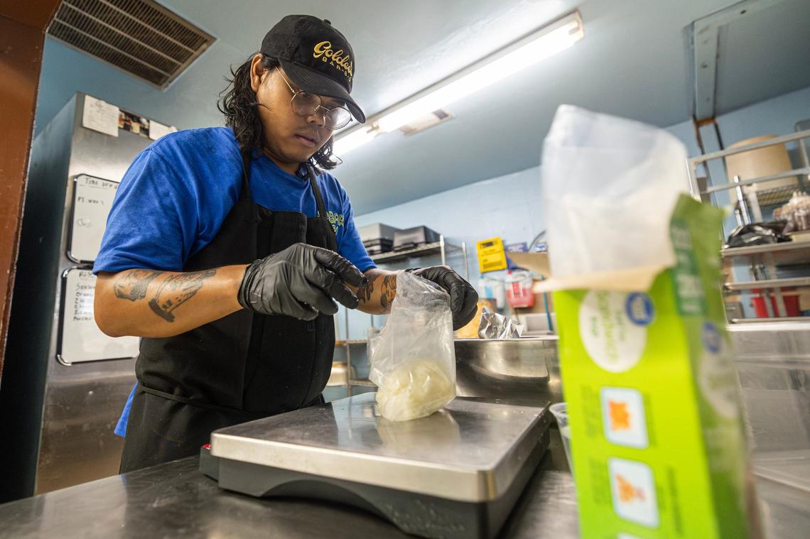 Nupohn Inthanousay, a co-owner of Goldee’s Barbecue, portions sticky rice into individual bags for the Lao Sausage prior to service at their kitchen in Fort Worth on Friday, June 28, 2024.