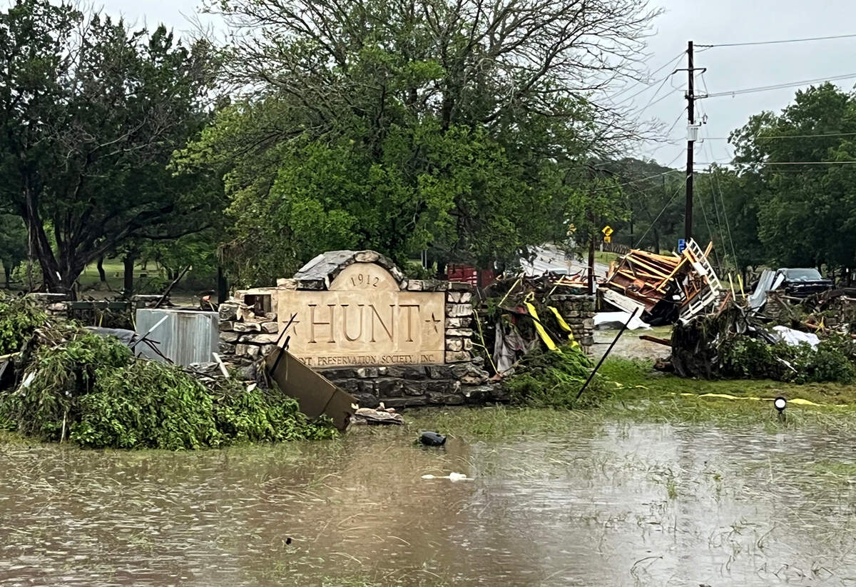 The Hunt Preservation Society sign surrounded by flood water and debris.