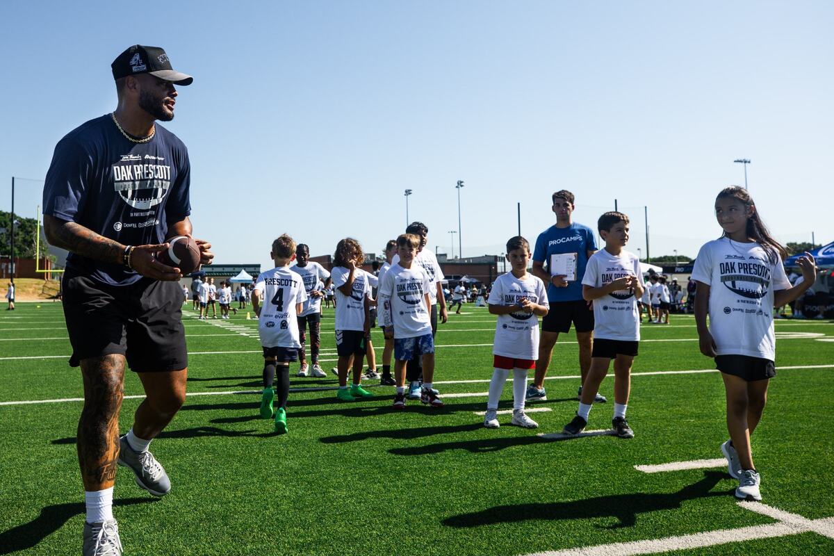 Dallas Cowboys Quarterback Dak Prescott sets to throw the ball during youth football pro camp on Tuesday July 9 at Carroll senior high school southlake practice field. Kids took turns catching the ball.