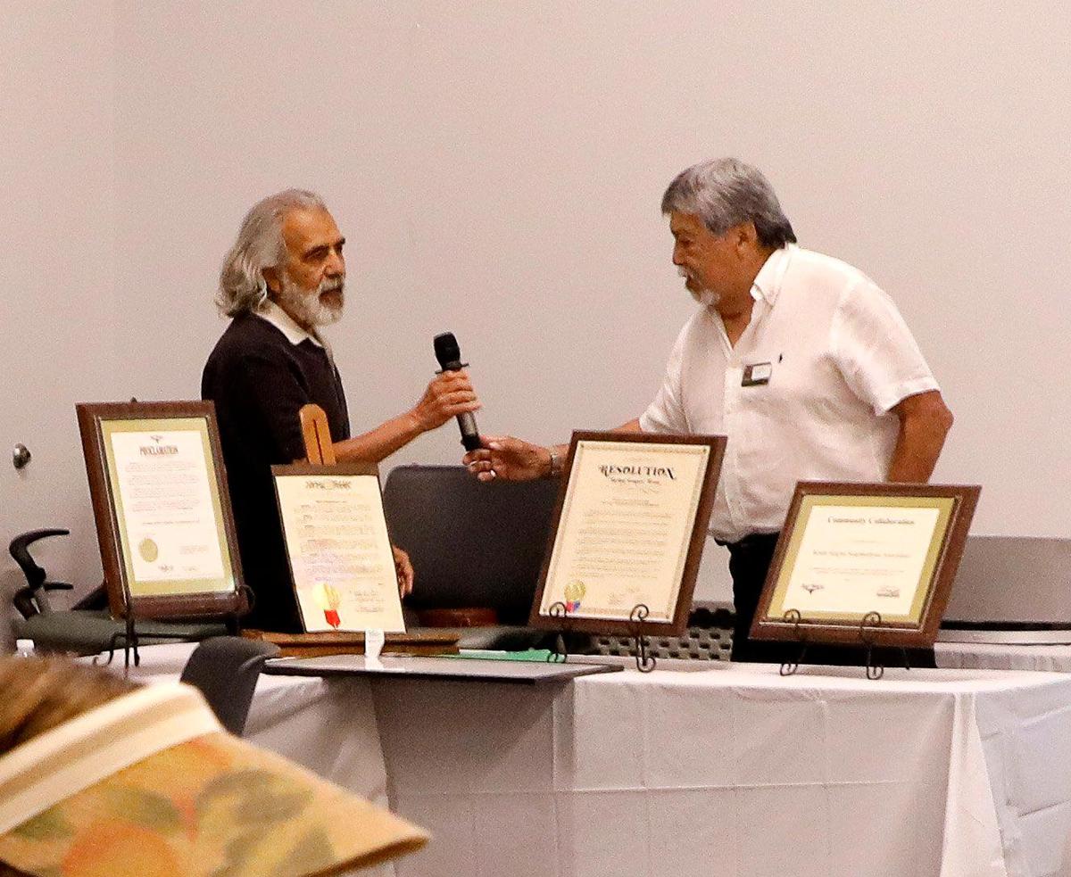Worth Heights Neighborhood Association president Joe Guerrero hands the mic over to Richard Gonzales during the 25th anniversary celebration at the Victory Forest Community Center in Fort Worth on Saturday, May 20, 2023. The celebration was held Saturday from 10 a.m. to 1 p.m.