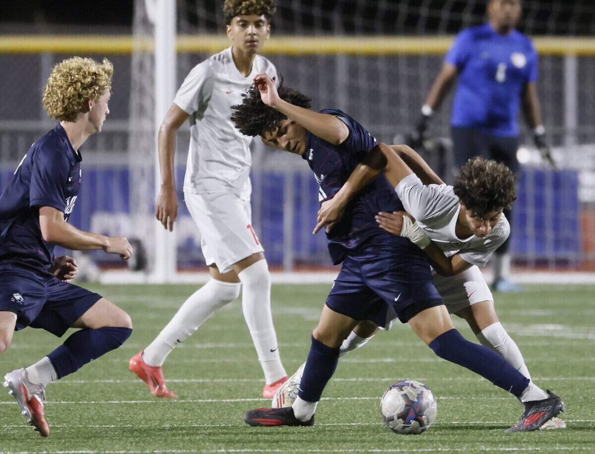 Allen midfielder Ethan Diaz (21) and Arlington Sam Houston Edson Morin (11) tangle up battling for the ball during the second half of a UIL area round boys soccer playoff game at Tommy Standridge Stadium in Carrollton, Texas, Tuesday, March 24, 2026.