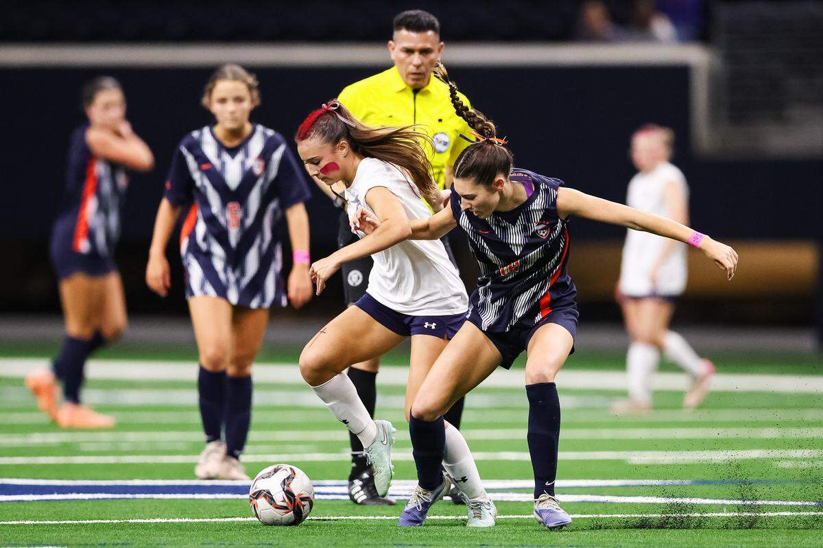 Grapevine’s Tatum Harig, center in white, fights off a Frisco Wakeland defender for the ball in a Class 5A Division II UIL girls soccer state semifinal at the Ford Center on April 3, 2026 in Frisco, Texas.