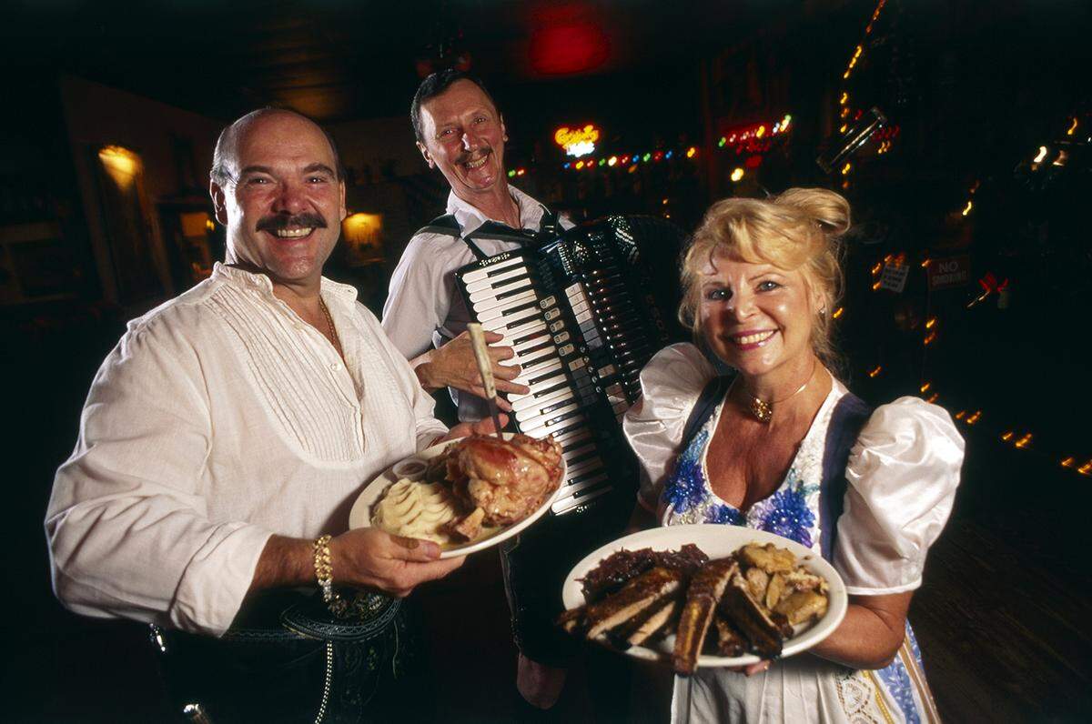 Aug. 4, 1995: The house band from Edelweiss. From left, Bernd Schnerzinger with the ham shank dinner, Jerry Ozdych, and Helga Beckman with the rib plate.