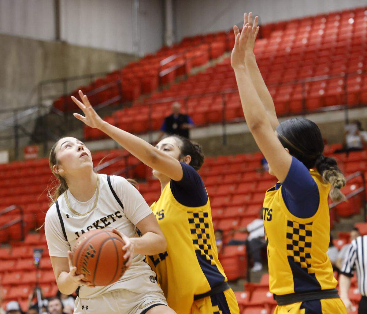 Cleburne center Lauryn Carrizales (11) gets double teamed by Arlington Heights under the net during the first half of the UIL 5A D1 girls bi-district championship basketball game at Wilkerson Greines Activity Center in Fort Worth, Texas, Monday Feb. 16, 2026.