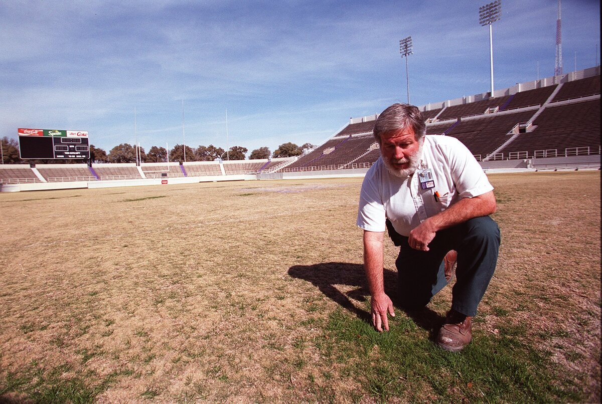 David Yarbrough, field supervisor at TCU Amon Carter Stadium looks over the winter rye grass growing on the TCU stadium. The grass is part of prank played by the SMU band that left the SMU band’s Diamond M in the middle of the Amon Carter Stadium.