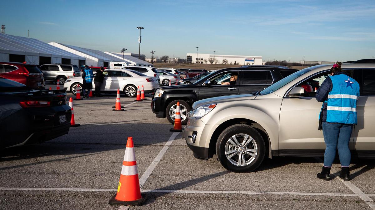 Volunteers check people in as they wait in their cars to receive the COVID-19 vaccination Tuesday, Feb. 2, 2021, at the Texas Motor Speedway.