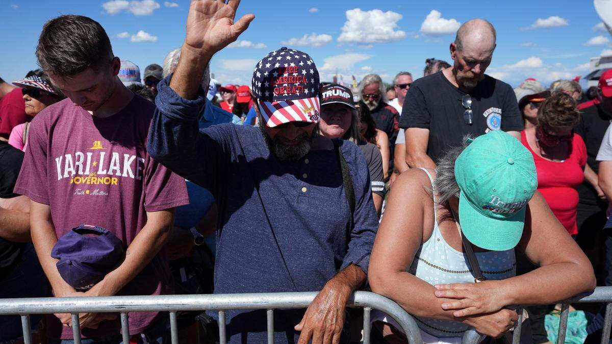 People gather in prayer at Legacy Sports Park in Mesa, Arizona, on Oct. 9, 2022, before a speech by former President Donald Trump.