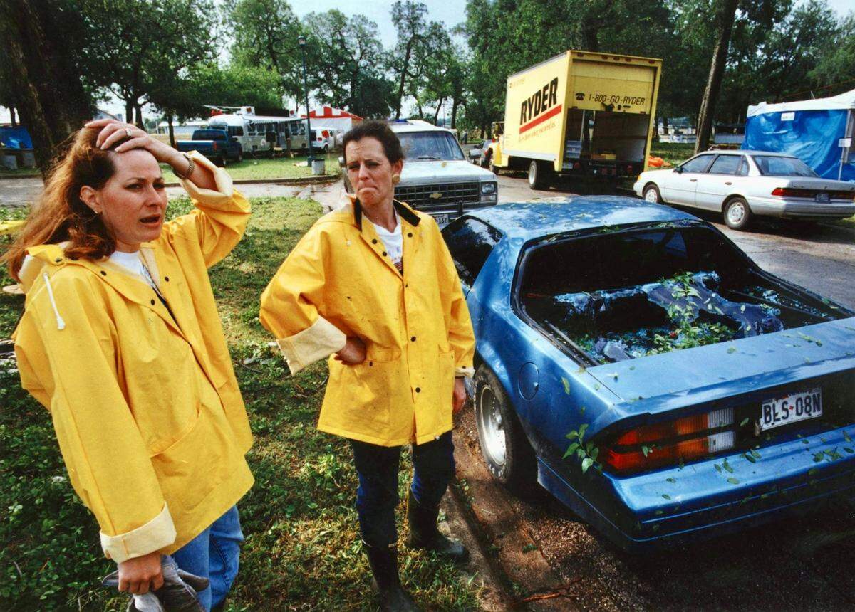 Mayfest committee volunteers Missy Carson and Charlotte Cummings survey broken glass and hammered cars at Trinity Park May 6, 1995, the day after the hailstorm.