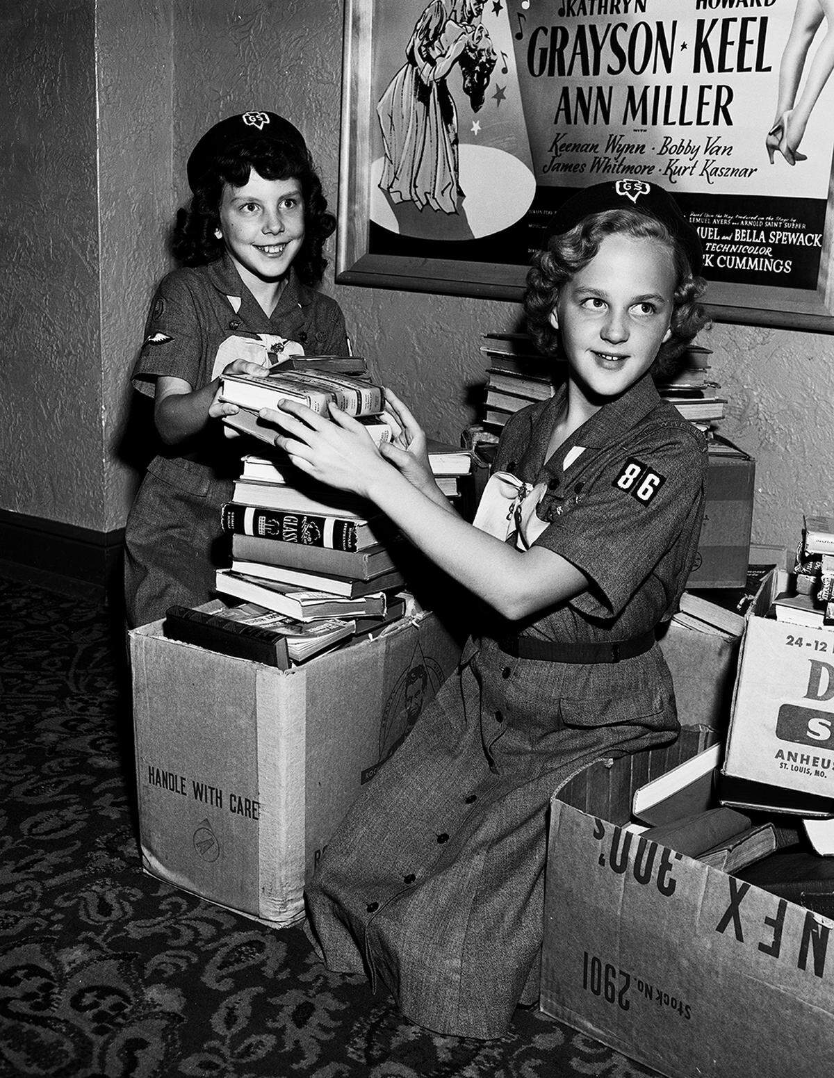 Nov. 14, 1953: Kathleen Sparks, 10, and Gwen Mapes (right), members of Girl Scout Troop 86, stack past of the volumes contributed to the Books for Servicemen Drive. Gwen won first place in competition for 1,082 books she and members of the troop collected.
