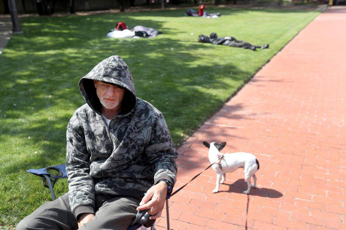 Gardner Russell sits with his dog, Tara, while waiting for the Fort Worth Convention Center to open its doors on Tuesday, April 14, 2020. The Convention Center is being used as an overflow shelter for Fort Worth homeless during the coronavirus pandemic.