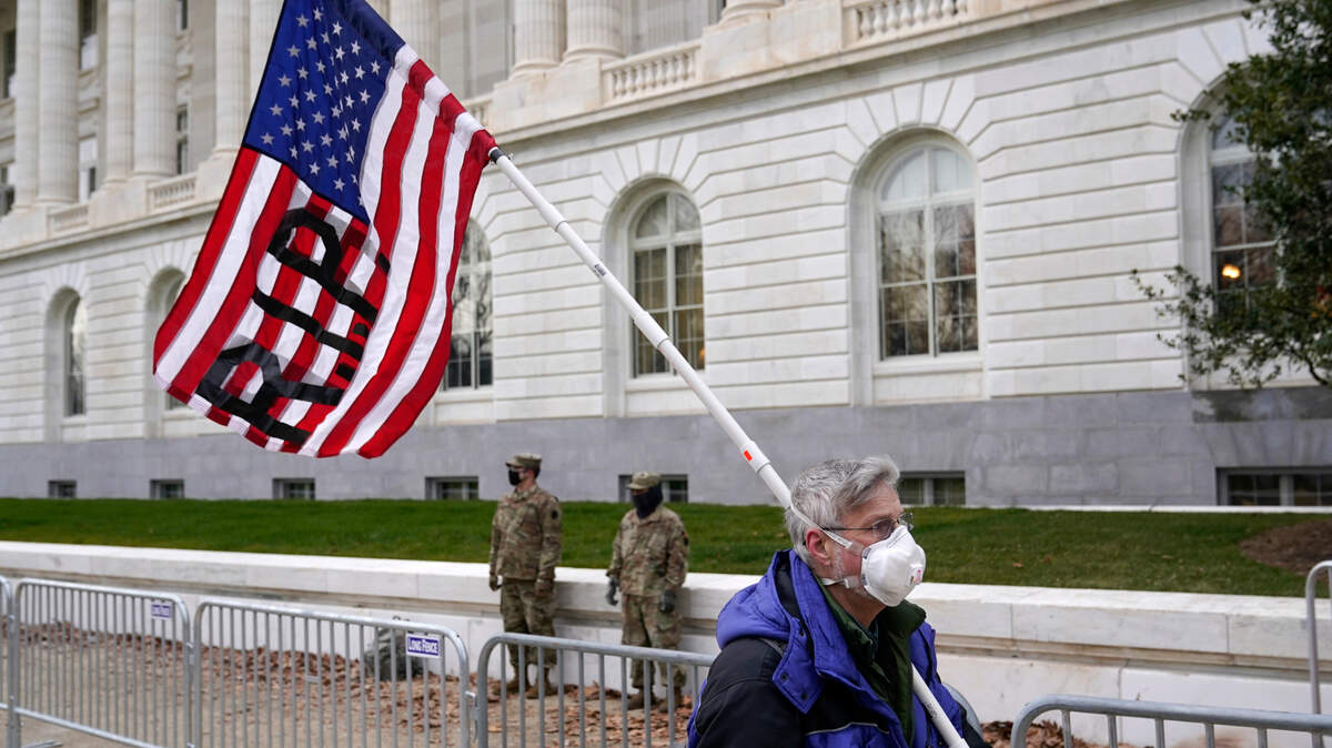 A protester walks past the Russell Senate Office Building on Capitol Hill in Washington, Friday, Jan. 8, 2021.