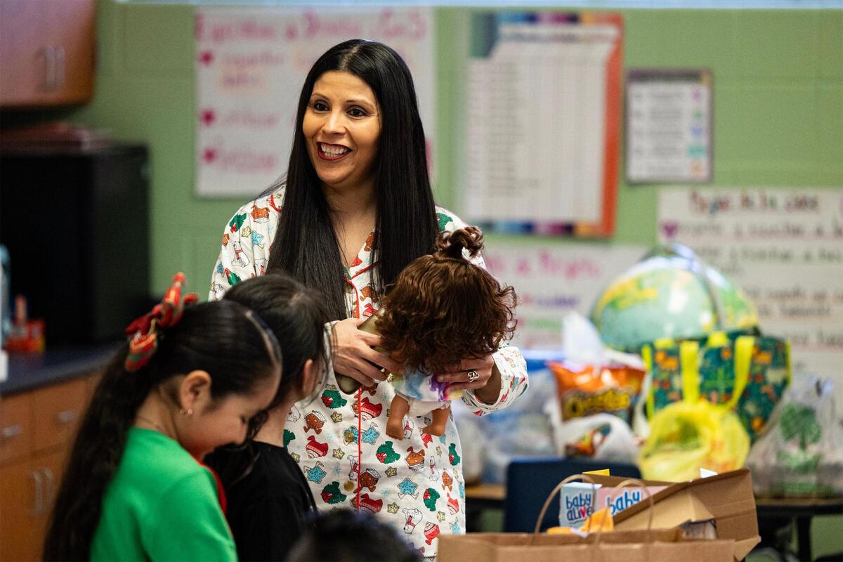 Amelia Cortes-Rangel, the principal of Alice Contreras Elementary, speaks to kindergarten students opening their Christmas presents in Sandra Keefe’s classroom at Alice Contreras Elementary School in Fort Worth on Thursday, Dec. 19, 2024.