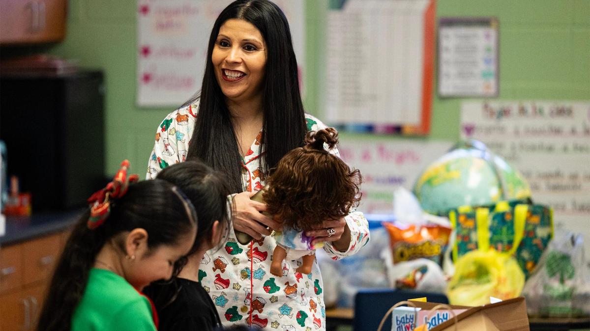 Amelia Cortes-Rangel, the principal of Alice Contreras Elementary, speaks to kindergarten students opening their Christmas presents in Sandra Keefe’s classroom in Fort Worth on Dec. 19, 2024.