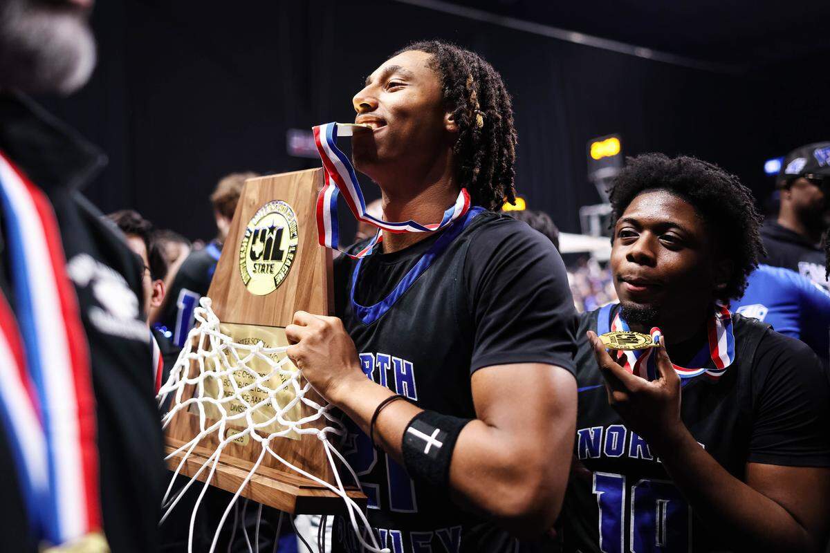 North Crowley wing Jonathan Fox holds the trophy in his hand and gold medal in his mouth after winning the Class 6A Division I state championship game against San Antonio Brennan on Saturday at the Alamodome in San Antonio.