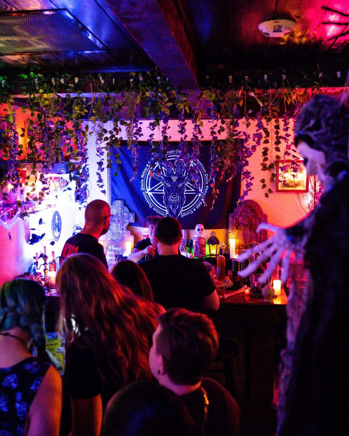 This photo shows people at the bar, which is decorated with spider webs and skeletons.