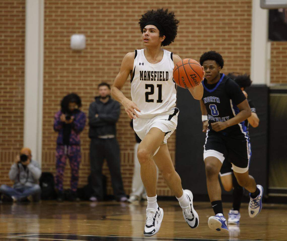 Mansfield's Judah Charles (21) brings the ball down court in front of North Crowley wing Bennjamin Jones (0) during the first half of a UIL boys basketball game between North Crowley and Mansfield at Mansfield High School in Mansfield, Texas, Tuesday Jan. 20, 2026