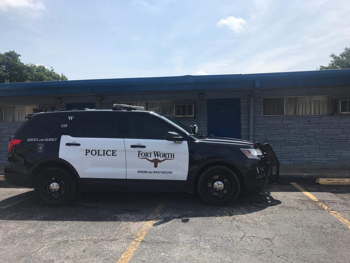 A police car sits outside of a room in the Golden Gate Motel where a man suspected of murder had been staying. Police had found the body of a woman in the room, police said.