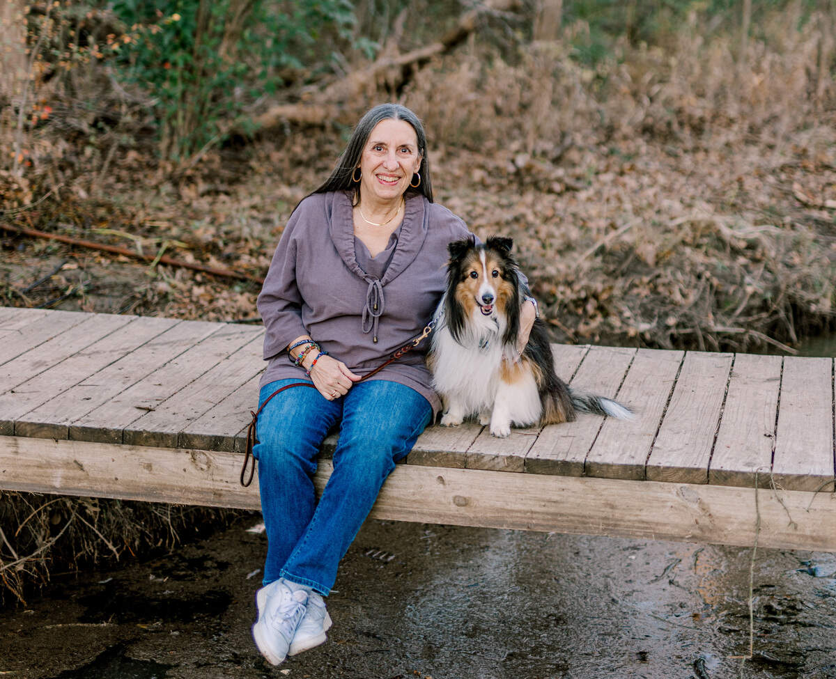 Wanda Cotter, left, sits beside her 12-year-old Sheltie, Tucker, right, on a wooden bridge near their home in Colleyville.