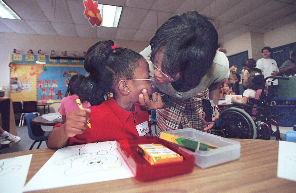 Aug. 9, 2000: Robin Kelly gets ready to plant a smooch on daughter Andraya Kelly’s forehead in Cheryl Young’s kindergarten class at Charlotte Anderson Elementary School in the Mansfield ISD.