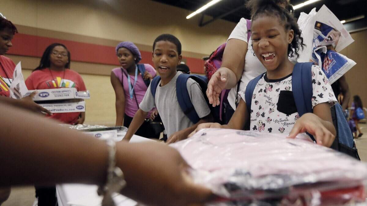 Sarinity Sims, 8, reacts to receiving a new pink backpack during the annual Back to School Roundup at the Will Rogers Memorial Center in Fort Worth.