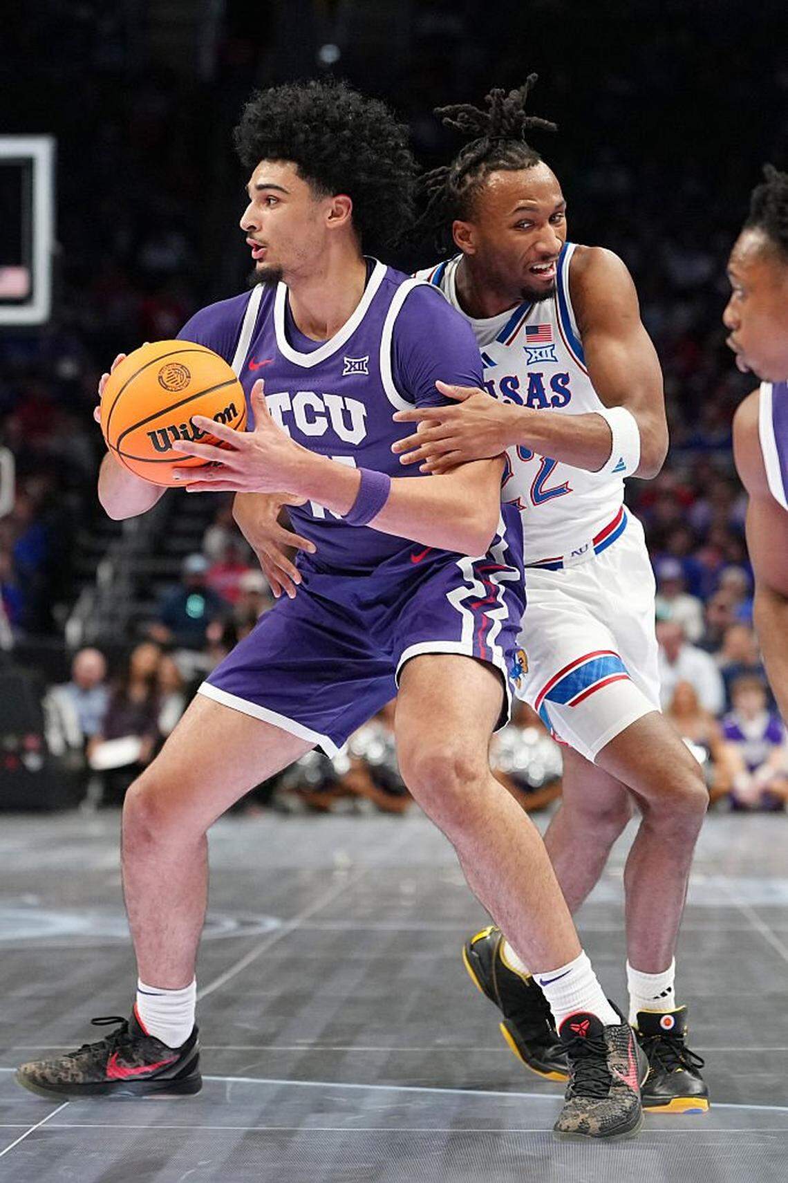 KANSAS CITY, MISSOURI - MARCH 12: Darryn Peterson #22 of the Kansas Jayhawks collides with David Punch #15 of the TCU Horned Frogs in the first half during the quarterfinals of the Big 12 Tournament at T-Mobile Center on March 12, 2026 in Kansas City, Missouri. (Photo by Ed Zurga/Getty Images)