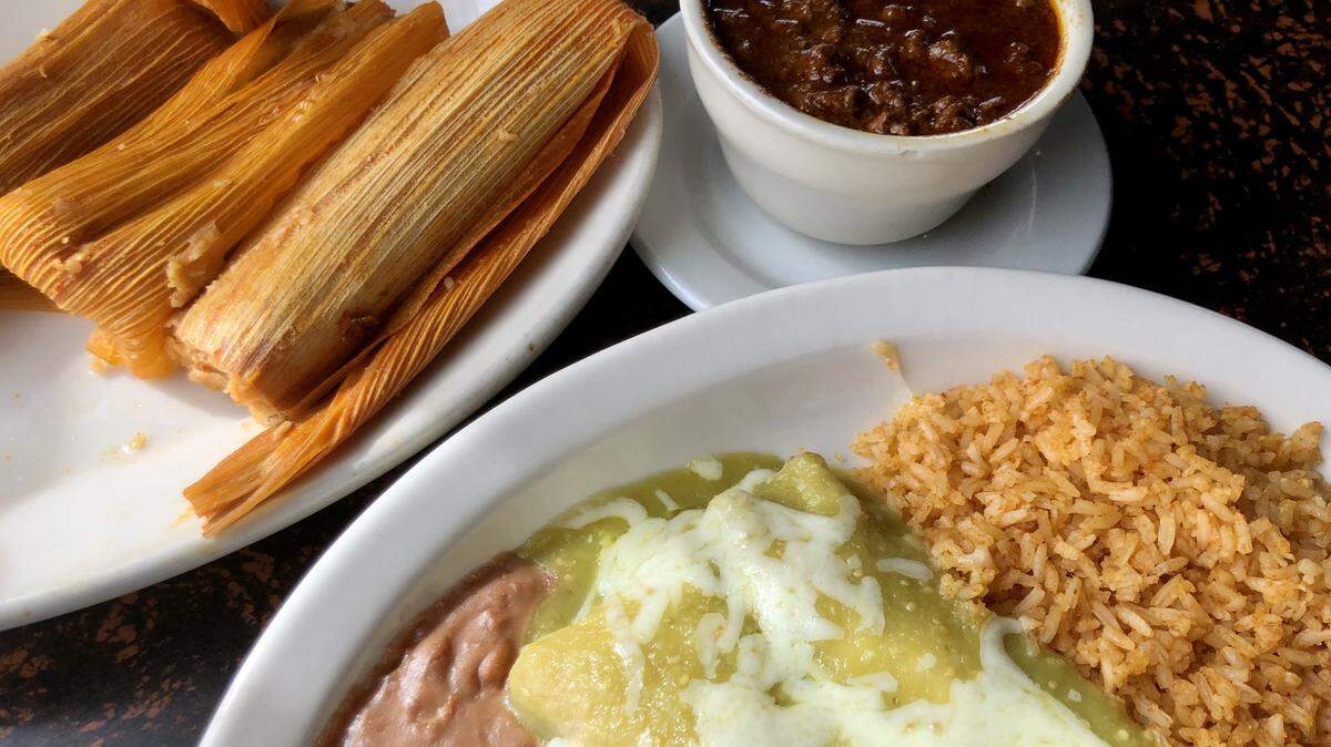 Green chicken enchiladas and pork tamales with a side of chili con carne at El Rancho Grande Mexican Restaurant.