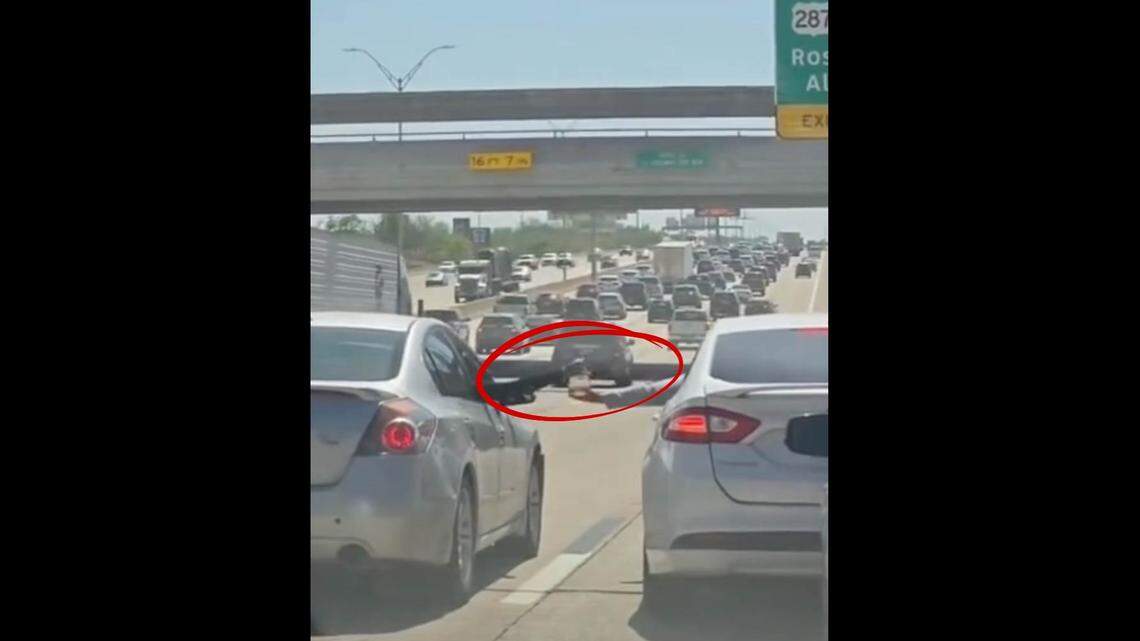 VIDEO: Drivers block traffic to pass liquor bottle on I-35 in Fort Worth