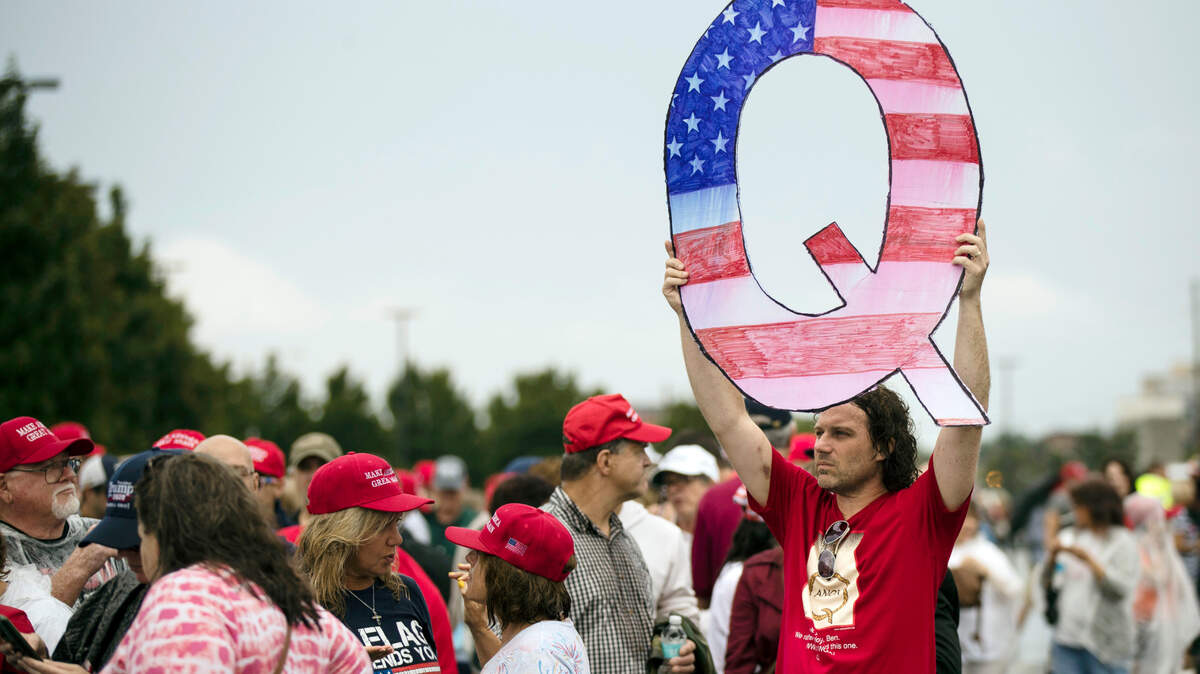 In 2018, David Reinert holds his QAnon ‘Q” sign as he waits to enter a Donald Trump campaign rally in Wilkes-Barre, Pa.