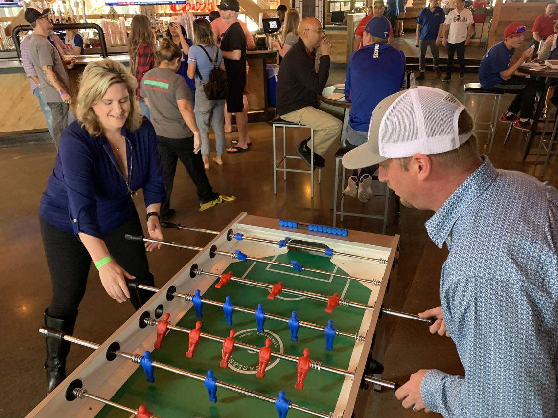 Sara and Chad Westenbroek play foosball Thursday at Texas Live!, a venue that was packed for the Texas Rangers baseball club’s opening day.