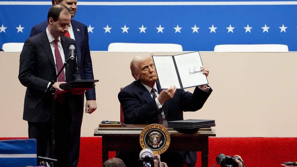 Jan 20, 2025; Washington, DC, USA; President Donald Trump signs a stack of executive orders on stage during the inauguration parade for President Donald Trump at Capital One Arena in Washington D.C., on Monday, Jan. 20, 2025. Mandatory Credit: Sam Greene-Pool via Imagn Images