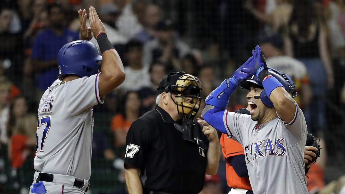 Robinson Chirinos, right, and Ronald Guzman were pretty excited Friday night after Chirinos’ two-run homer in the fifth and after learning that neither of them had been traded.