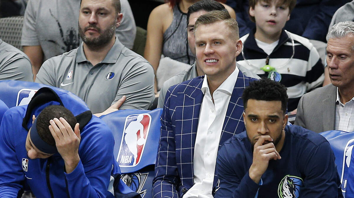 Dallas Mavericks forward Kristaps Porzingis, center, looks on from the bench during the first half of an NBA basketball game against the Portland Trail Blazers, Friday, Jan. 17, 2020, in Dallas. Dallas won 120-112. (AP Photo/Brandon Wade)
