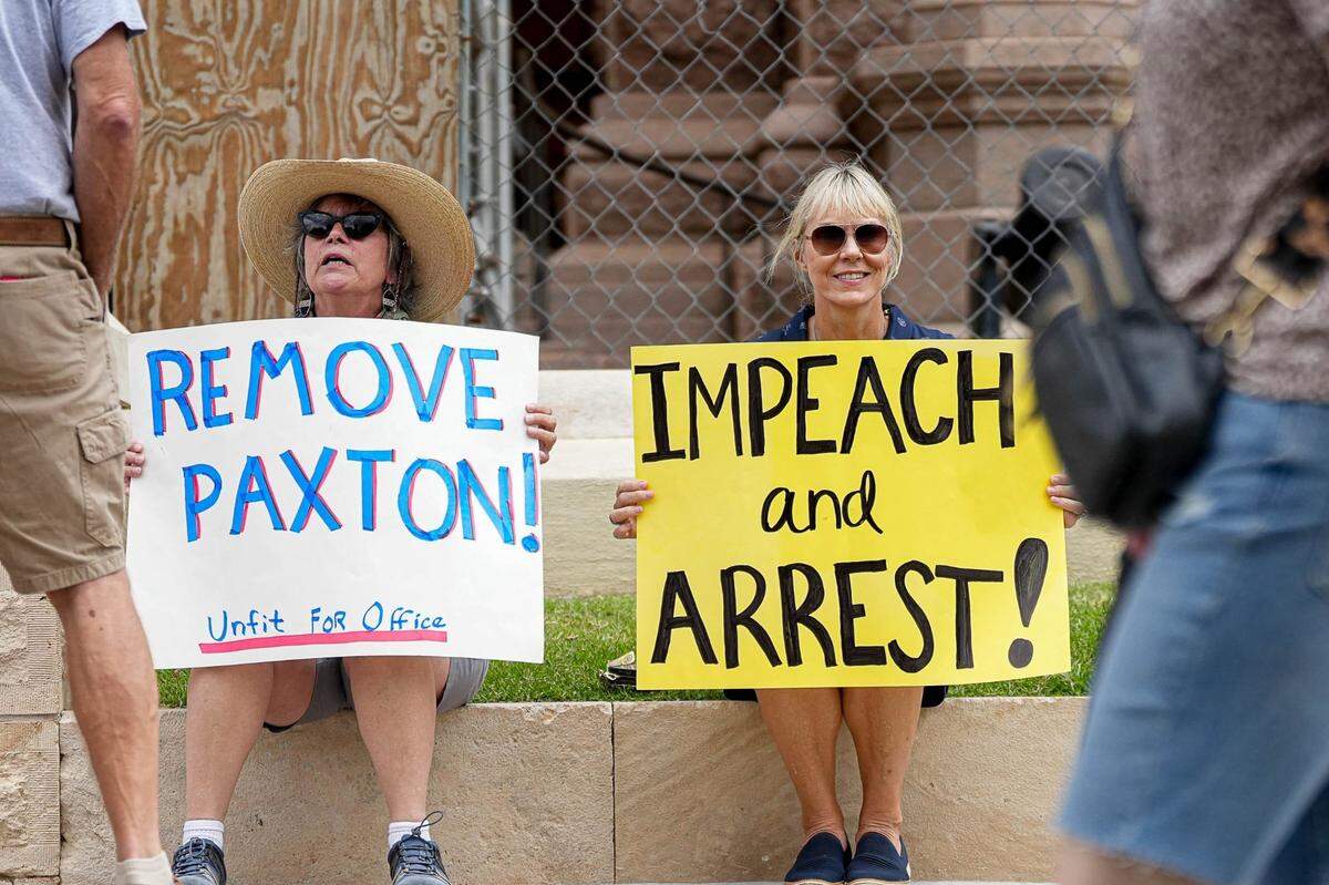 Stephanie Lucie, right, and Lynn Tozser, left, protest in favor of impeaching Texas Attorney General Ken Paxton at the Texas Capitol on Saturday, May 27, 2023. The House voted in favor of impeaching Paxton 121-23 with two present, not voting and three absent.