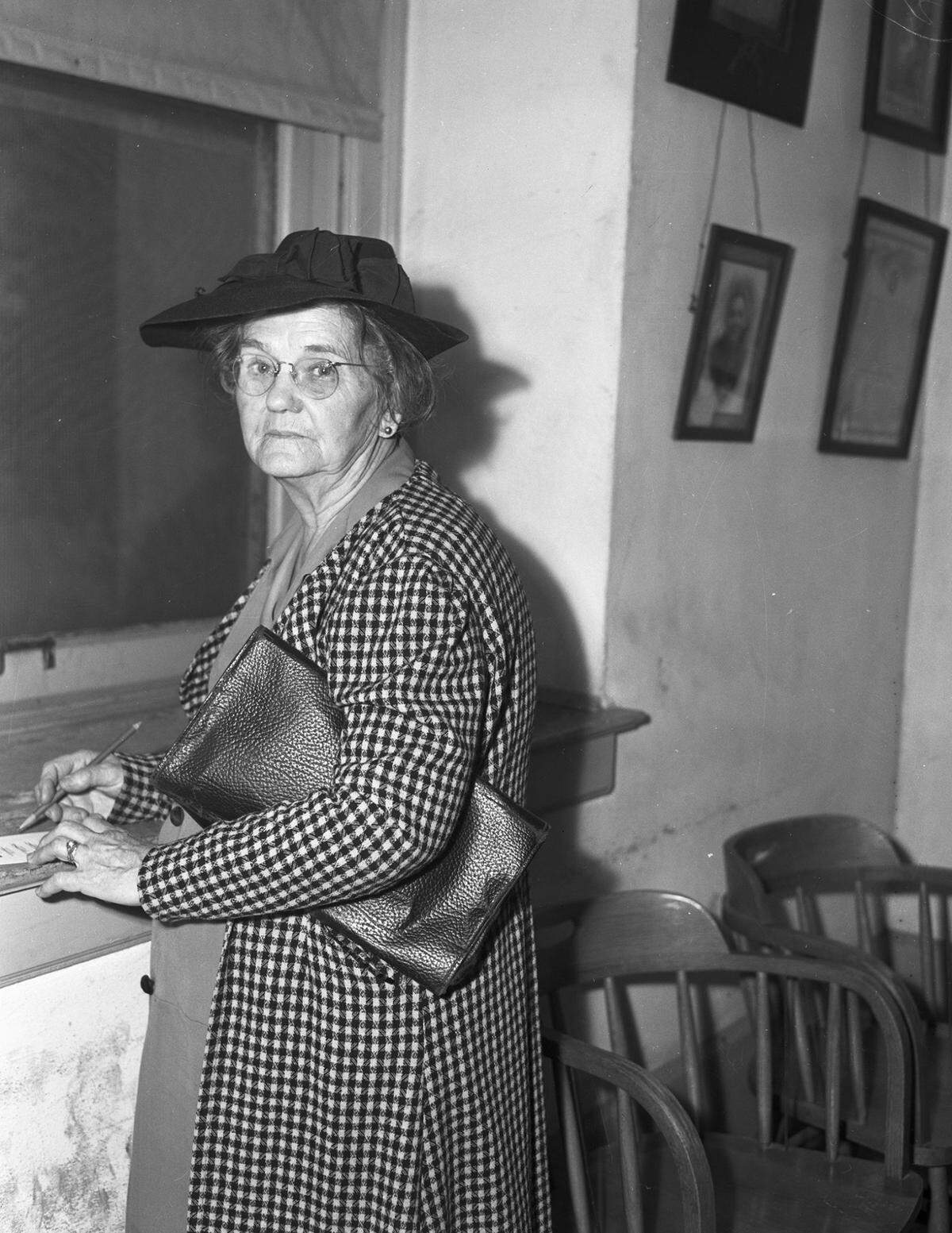 April 2, 1945: Mrs. J. H. Luther standing with a pencil in her hand as she marks on a voting slip in the Fort Worth city election.