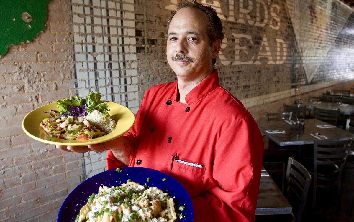The owner and chef of Lili’s Bistro, Vance Martin, poses with the grilled talapia with cilantro rice and the gorgonzola fries in Fort Worth on May 30, 2007.
