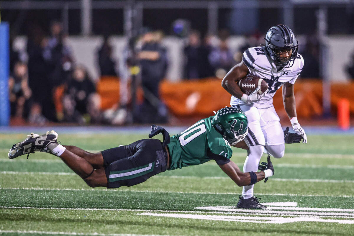 Martin running back Daylon Cobb runs the ball as Arlington defender Dermon Cunningham dives at his legs during the Thursday, Nov. 7 game at UTA’s Maverick Stadium in Arlington. Special to the Star-Telegram / Tom Marvin