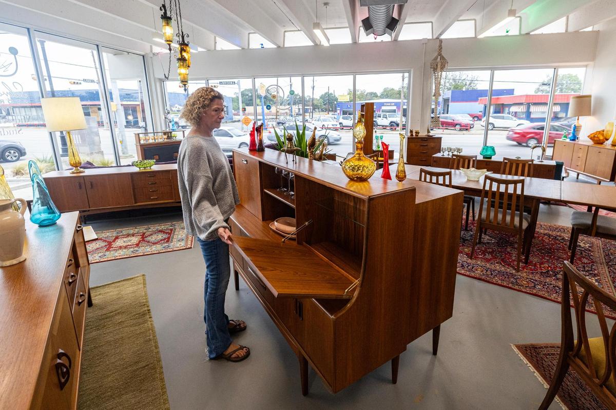 Jennifer Kemp, the co-owner of Salvaged Stories furniture store, rearranges her showroom furniture at her retail space at the corner of E Division Street and N East Street in Arlington. She’s one of around a dozen Urban Union tenants.