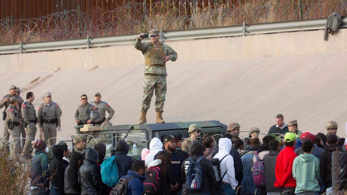 Migrants crossed the Rio Grande and approach the Texas National Guard to inquire when they will be allowed to be processed by Customs and Border Protection to seek asylum in El Paso, Texas on Dec. 20, 2022.