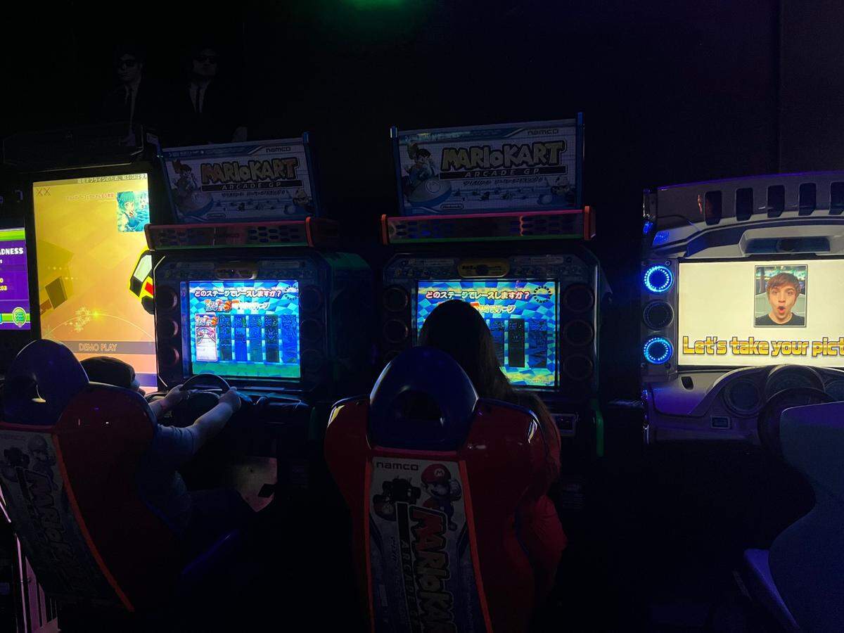 Free Play Arcade customers playing Mario Kart games, one of dozens of options offered.
