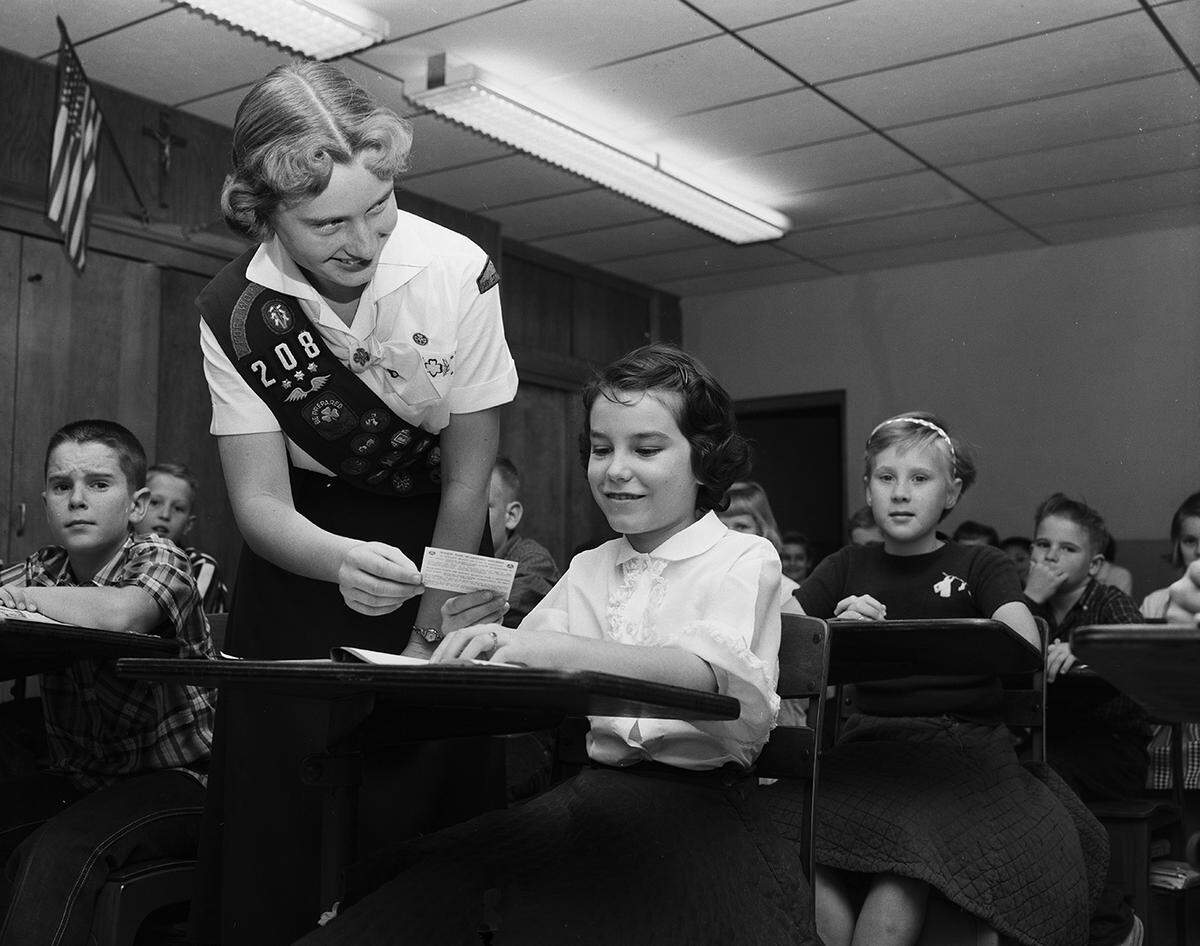 Dec. 5, 1958: Barbara Grew, left, 13, passes out a civil defense preparedness card to Linda Eastman, 11, of Route 5. The girls are students at St. Alice School. The Tarrant County Girl Scout Council passed out the billfold-sized cards to all the children in county public and parochial schools. The cards give instructions to families on preparing for enemy attack.