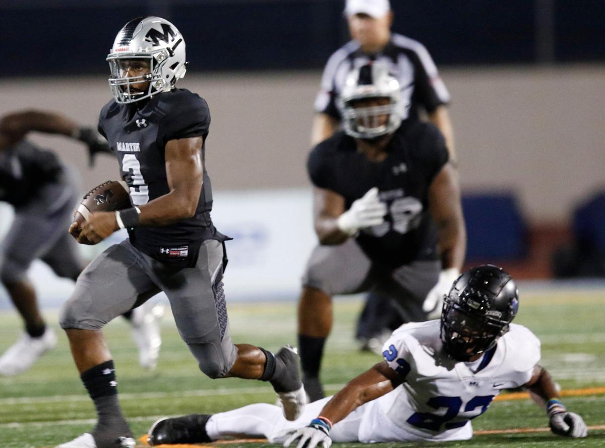 Martin’s Dwayne Williams (3) runs out of the tackle by Hebron’s Darius Snow (23) in second half action. The Hebron Hawks played the Martin Warriors at Maverick Stadium in Arlington Thursday, Sept. 5, 2019.