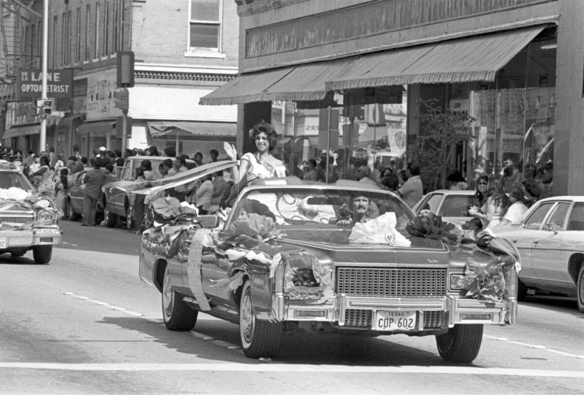 Sept. 18, 1977: A candidate for the Mexican Independence Day fiesta queen is seen sitting on the back of a convertible waving to people in the crowd during the parade.