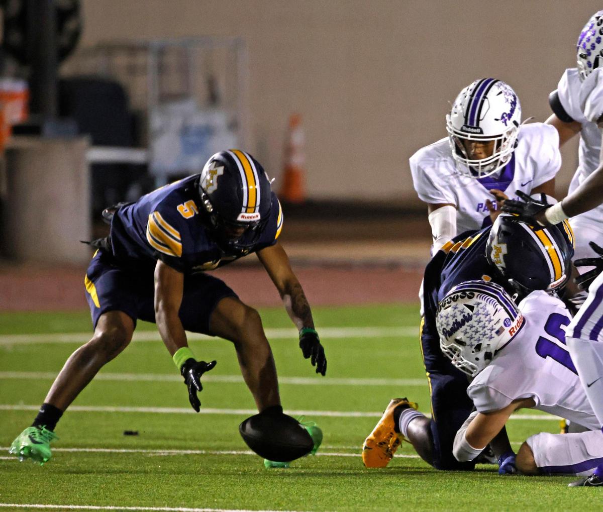 Arlington Heights wide receiver Jakob Hemphill (5) picks up the James fumble during the Battle of the Bonfire UIL District 4-5A D1 football game at Farrington Field in Fort Worth, Texas, Friday, Nov. 08, 2024.
